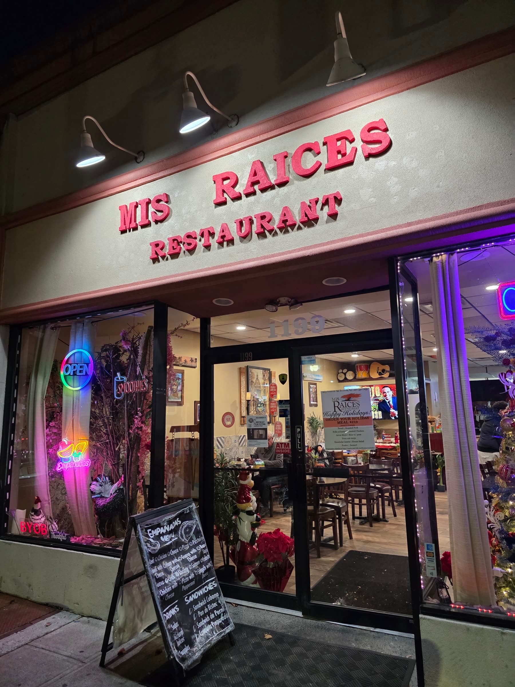 Fachada de Mis Raíces Restaurant en Teaneck, de noche